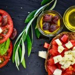 A vibrant Greek salad featuring tomatoes, feta, and olives on a slate board, perfect for healthy eating.